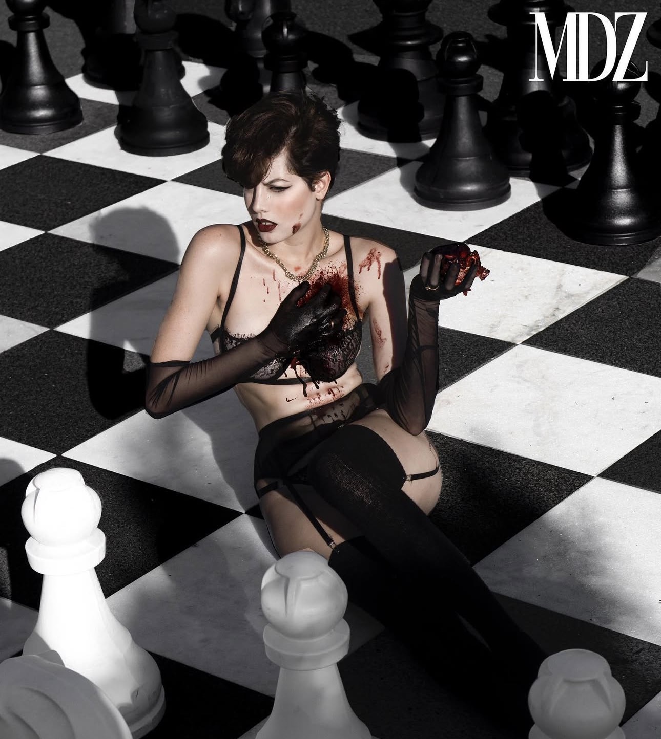 Modelizo chess shoot, model seated on a giant chessboard