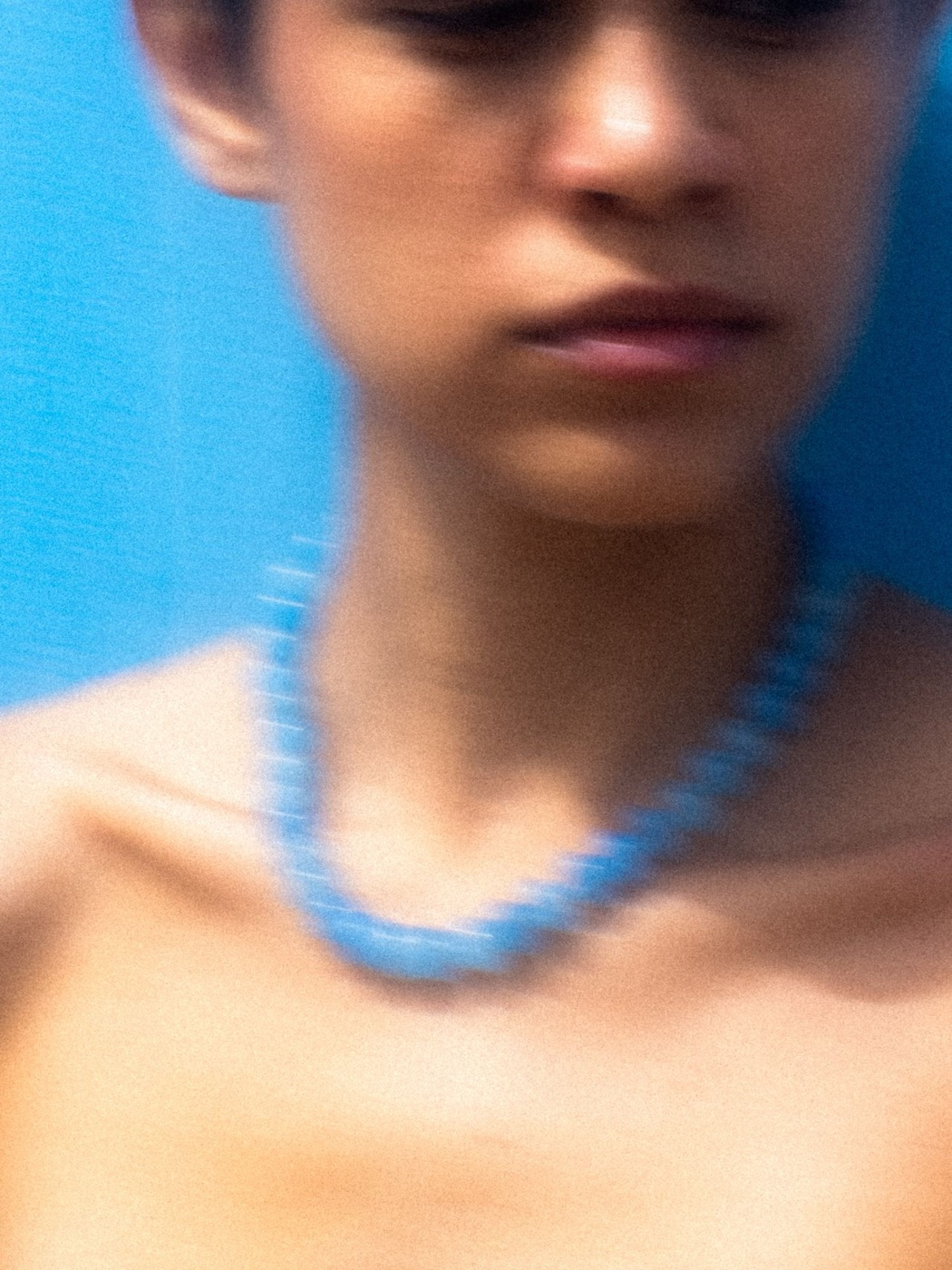 Sicels: blurred close-up of the blue necklace on the neck